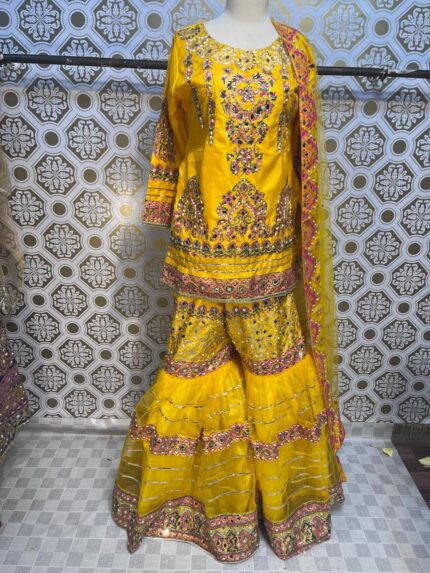 Yellow Gharara Set Brighten your wardrobe with our radiant Yellow Gharara Set. This stunning ensemble features a vibrant yellow gharara with a voluminous, layered skirt that gracefully flares out. The intricate embroidery and embellishments add a touch of elegance, making it perfect for special occasions and celebrations. Paired with a matching or complementary top, this set offers a seamless blend of style and comfort. Embrace a chic, festive look with this eye-catching, elegant outfit. Yellow Gharara Set Add a splash of sunshine to your wardrobe with our Yellow Gharara Set. This striking outfit features a vibrant yellow gharara with a gracefully layered skirt and exquisite embroidery that captures attention. The set includes a matching or complementary top, designed to enhance the overall elegance. Perfect for special events and festive occasions, it combines style and comfort for a radiant look that shines.